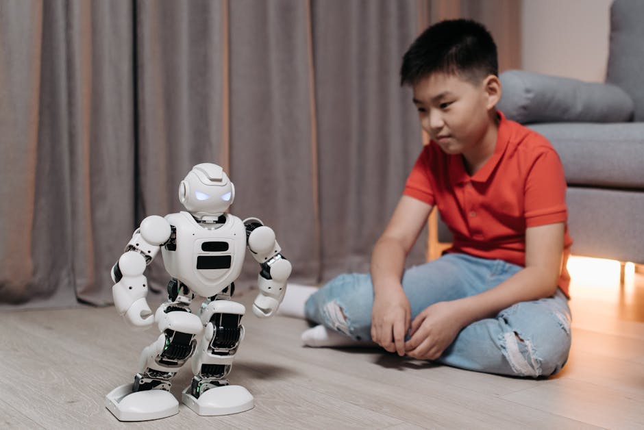 An asian boy sitting on the floor, interacting with a white robot, showcasing innovation and technology.