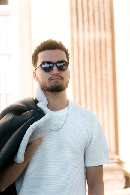 A fashionable man in sunglasses poses confidently in Potsdam, Brandenburg, Germany.