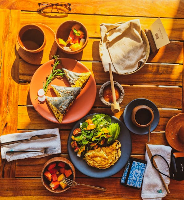 Top view of a vibrant Oaxacan breakfast with various dishes on a wooden table, capturing local flavors.