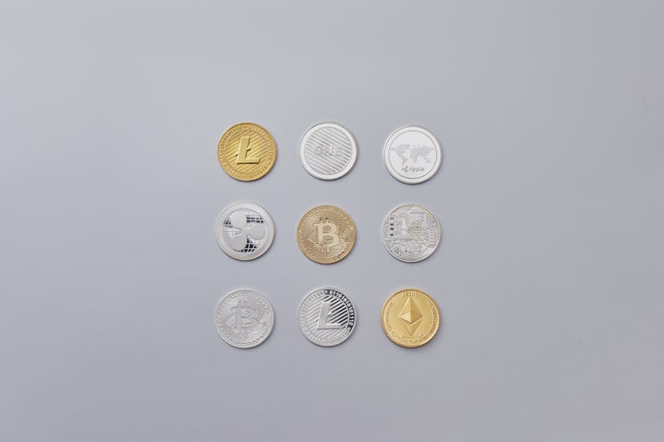 Image showcasing a selection of different cryptocurrency coins arranged on a neutral grey background.
