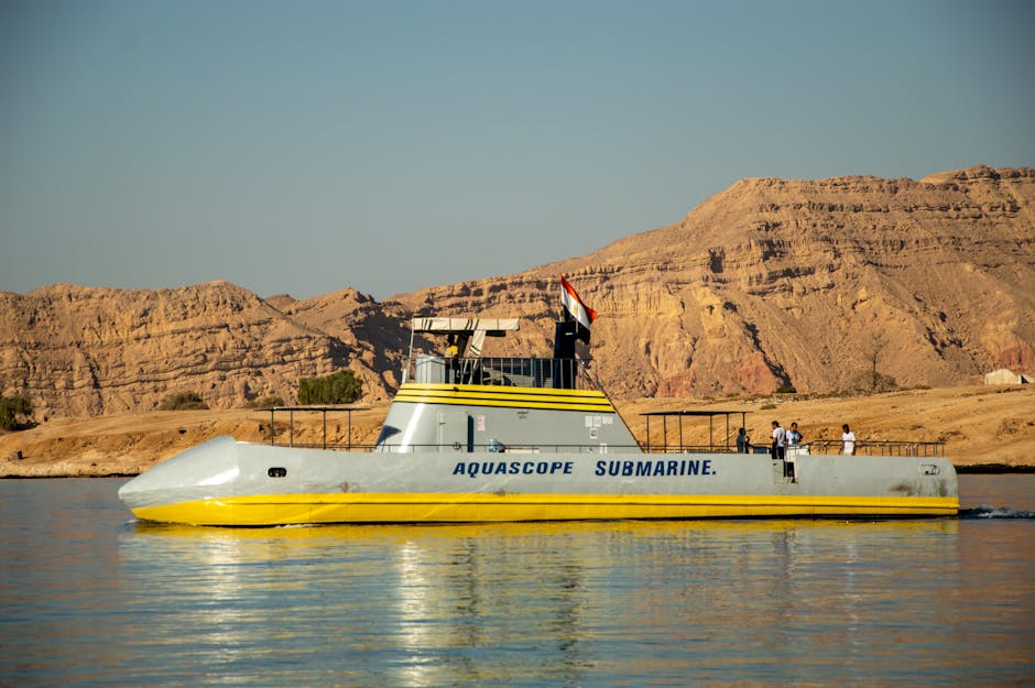 Vivid image of AquaScope submarine sailing near rugged Egyptian desert landscape. Bright, clear day.