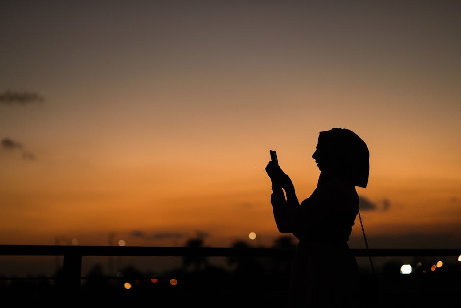 Abu Dhabi skyline with person holding smartphone government app