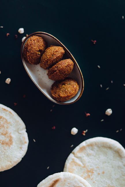 Close-up shot of crispy falafel served with fresh pita bread on a dark background.