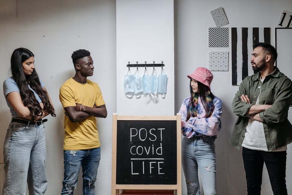 A group of diverse adults discussing life after COVID-19 indoors, highlighting socialization and safety.