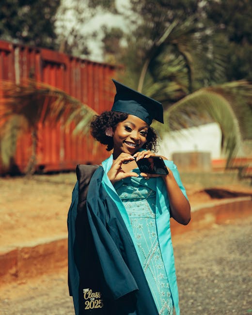 A smiling graduate in cap and gown takes a selfie, celebrating the class of 2025.