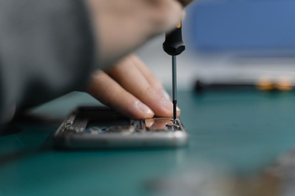 customer handing smartphone to technician repair shop subscription contract