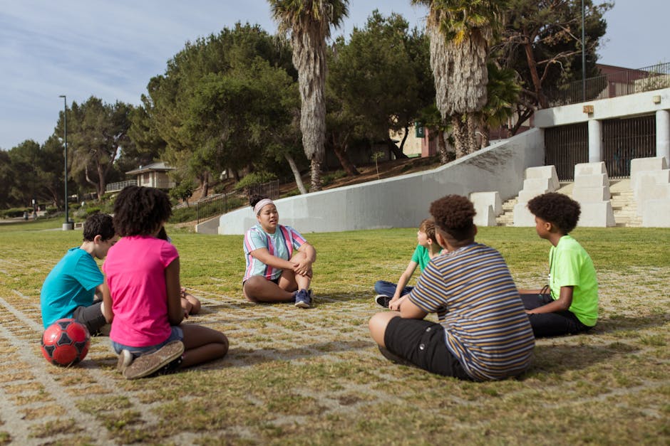 Group of kids discussing and learning outdoors in a park setting.