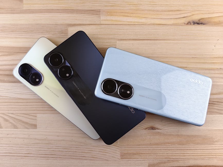 Three modern smartphones displayed on a wooden surface, showcasing design and color variants.
