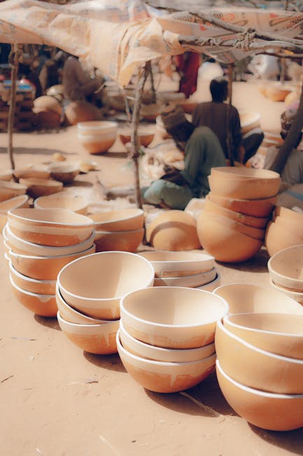 A vibrant scene at a Nigerian market showcasing handmade pottery bowls.