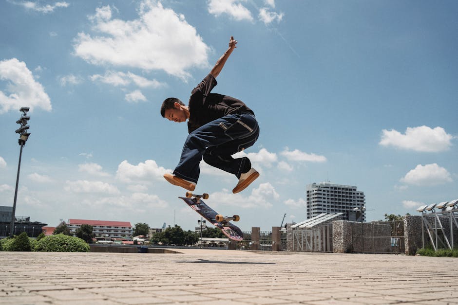 A skilled skater executing an impressive trick in an outdoor urban environment under a clear blue sky.