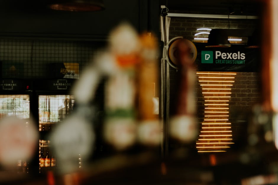 Warm ambiance of a pub with blurred focus, showcasing a Pexels Creators Summit sign.