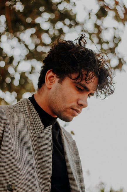 Young man with curly hair in elegant outdoor fashion portrait, ميت غمر, مصر.