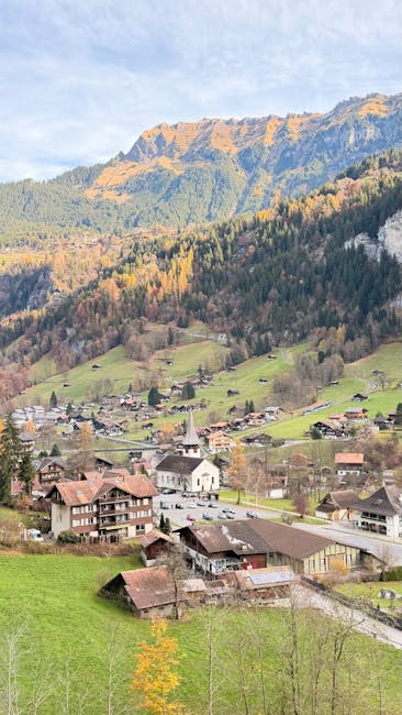 Charming autumn view of Lauterbrunnen village, nestled in the Swiss Alps with vibrant fall colors.