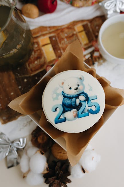 White cake with 2025 bear design surrounded by festive holiday decor and warm tones.