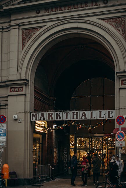 A grand archway at the entrance to Markthalle in Berlin, bustling with city life.