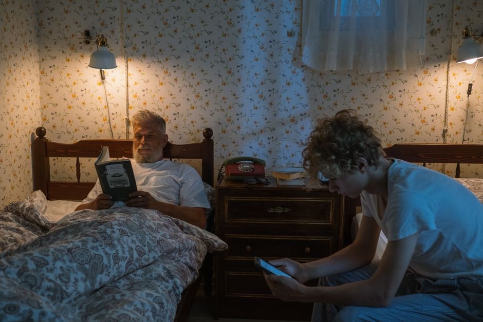 teenager reading book phone away evening calm bedroom