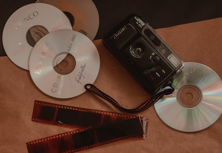 Retro collection featuring vintage camera, film negatives, and CDs for nostalgic photography enthusiasts.