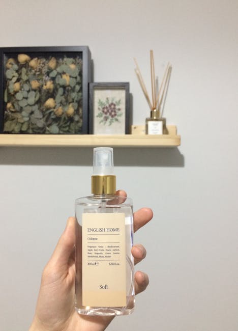 A fragrance bottle is held in a hand with decorative shelves in the background, conveying a sense of elegance.