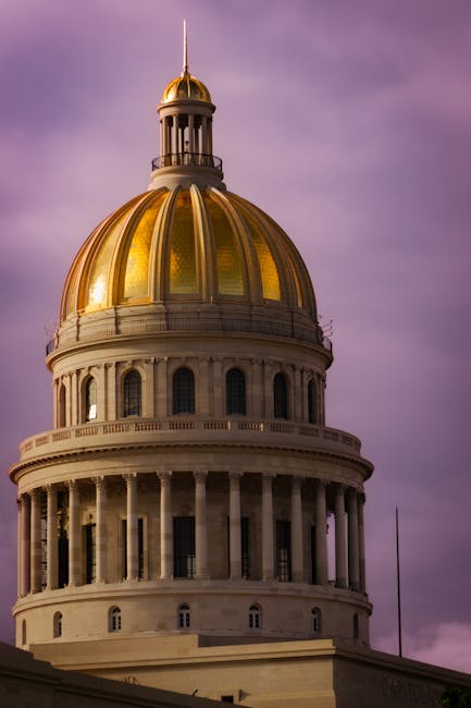 Golden dome of El Capitolio against a pink sky in Havana, a symbol of Cuban architecture.