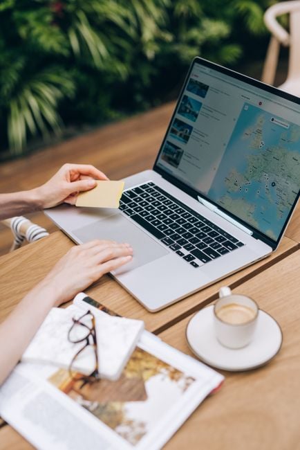 person using laptop booking travel app at cafe privacy