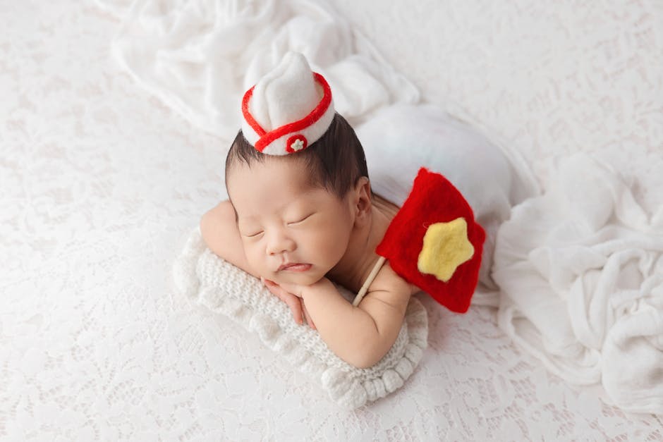 A sweet newborn baby peacefully sleeping with a Vietnamese flag accessory in a soft, cozy setting.