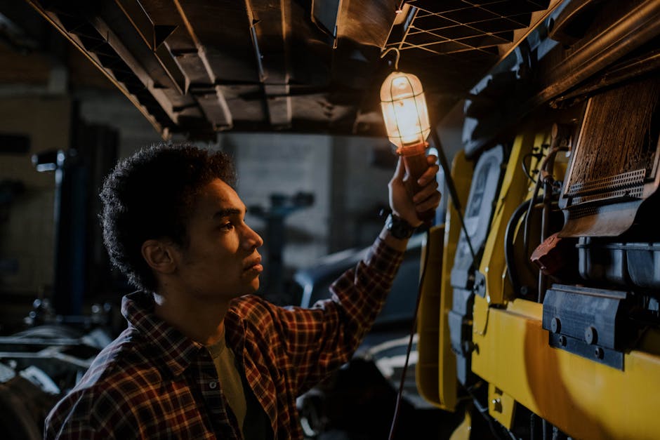 mechanic wearing PPE working on electric vehicle battery workshop