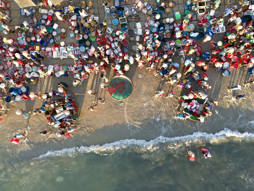 A lively overhead shot capturing the vibrant activity at a bustling beach market in Vietnam.