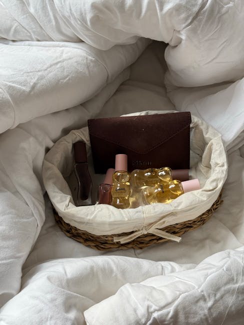 A cozy basket filled with essential oil bottles and a brown wallet on a soft bed.