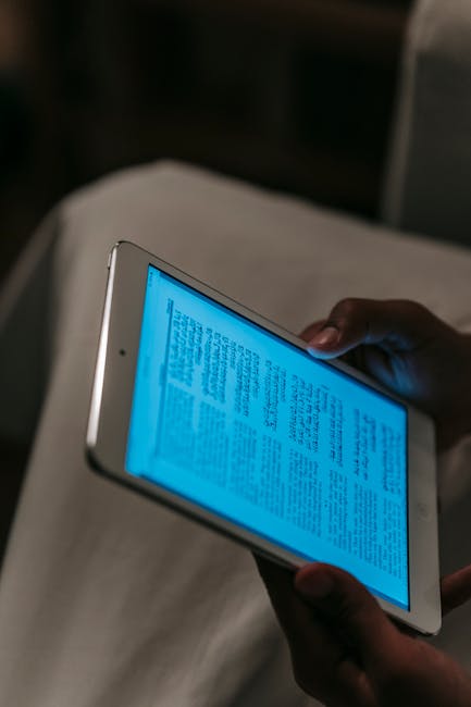 Close-up of hands holding a tablet displaying a digital book.