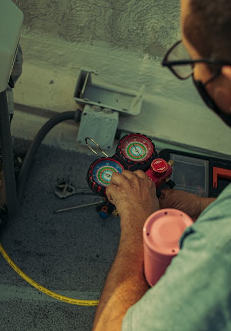 Professional technician adjusting a refrigerant manifold gauge for air conditioning maintenance.