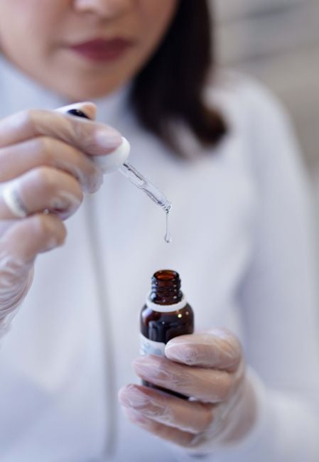 Close-up of scientist using pipette with liquid in laboratory environment.