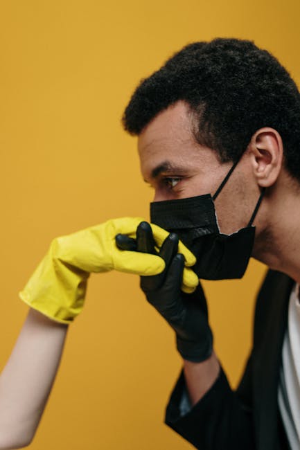A couple engages in a romantic gesture while wearing masks and gloves, symbolizing love in pandemic times.
