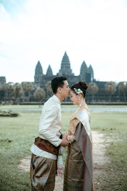 A couple in traditional Khmer clothing shares an intimate moment at Angkor Wat, Cambodia.
