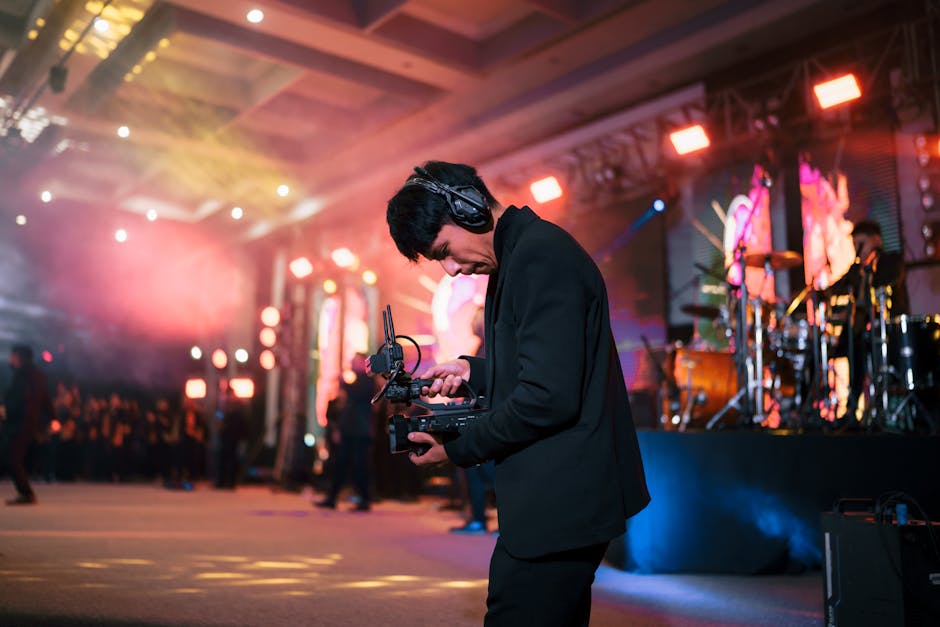 A photographer with equipment capturing a vibrant indoor concert in San Cristóbal de las Casas, Mexico.