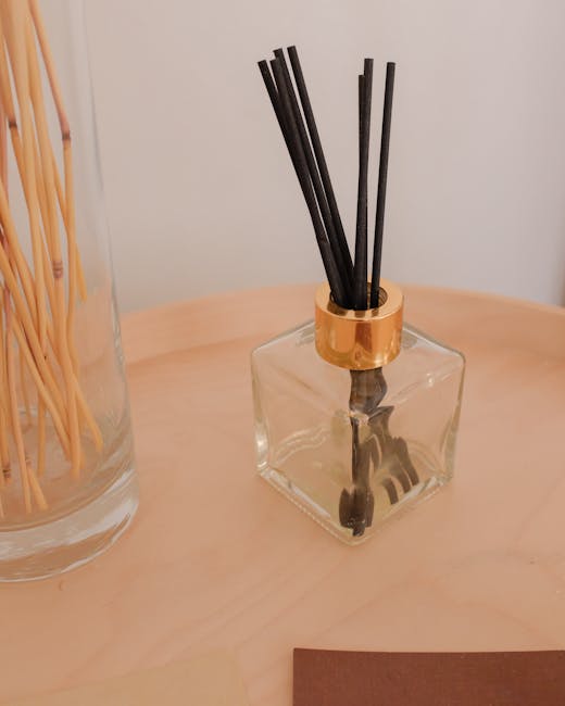 Close-up of a stylish aromatherapy diffuser with incense sticks on a wooden surface.
