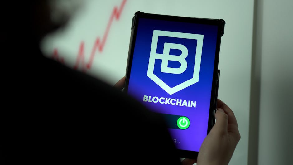 Close-up of hands holding a tablet with blockchain logo on screen, indicating crypto technology.