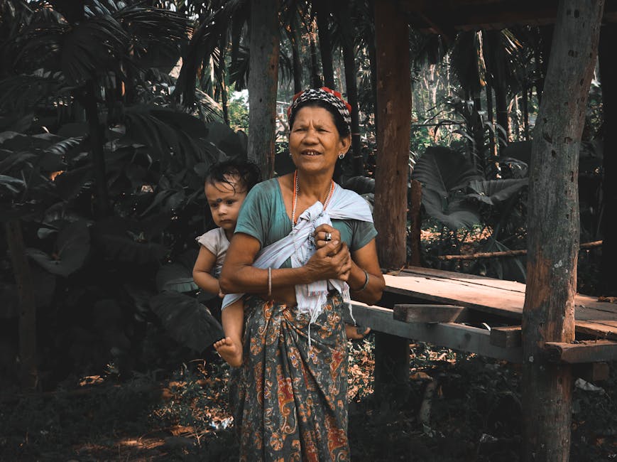 A mother lovingly carries her child amidst a dense, tropical jungle setting, showcasing nature and family bond.
