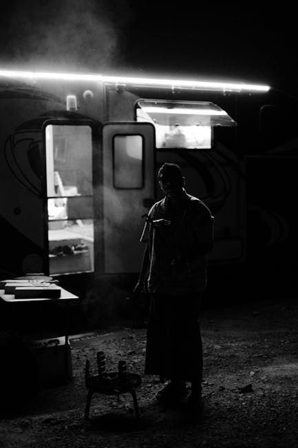 Dramatic black and white image of night camping in Showkah, UAE with food preparation.