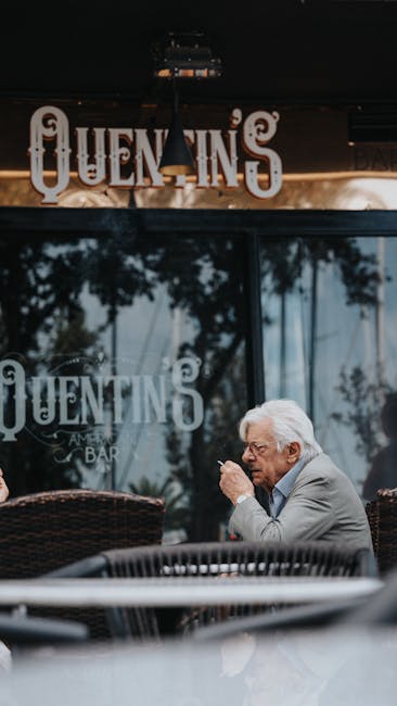 Senior man enjoys a cigarette in a stylish suit outside Quentins Bar.