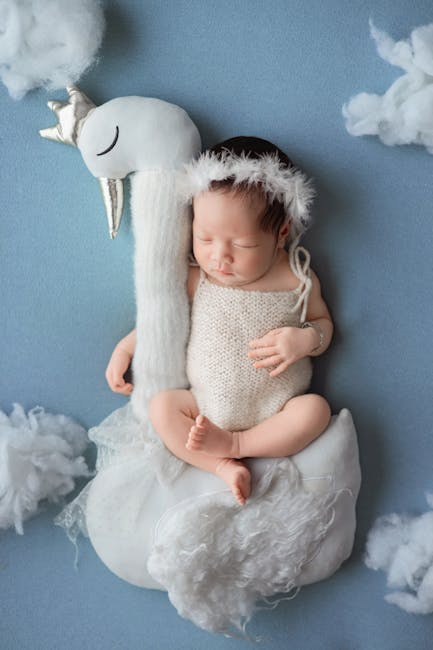 sleeping newborn with baby monitor in nursery camera soft light