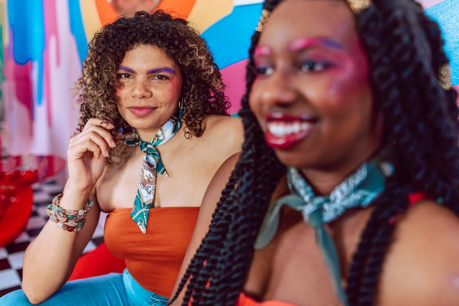 Vibrant image of two women with colorful makeup and joyful expressions.
