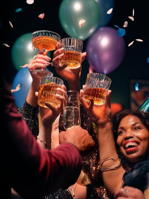 Group of friends raising glasses in a joyful toast, celebrating with balloons and confetti.