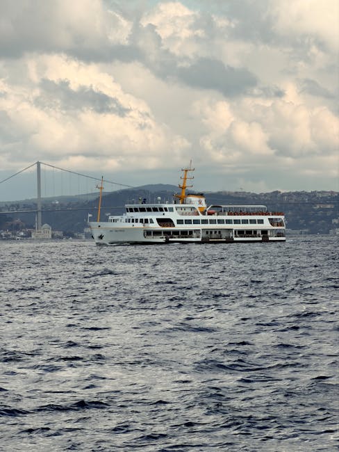 A ferry cruises on the Bosphorus with the iconic bridge in the background, Istanbul, Turkey.