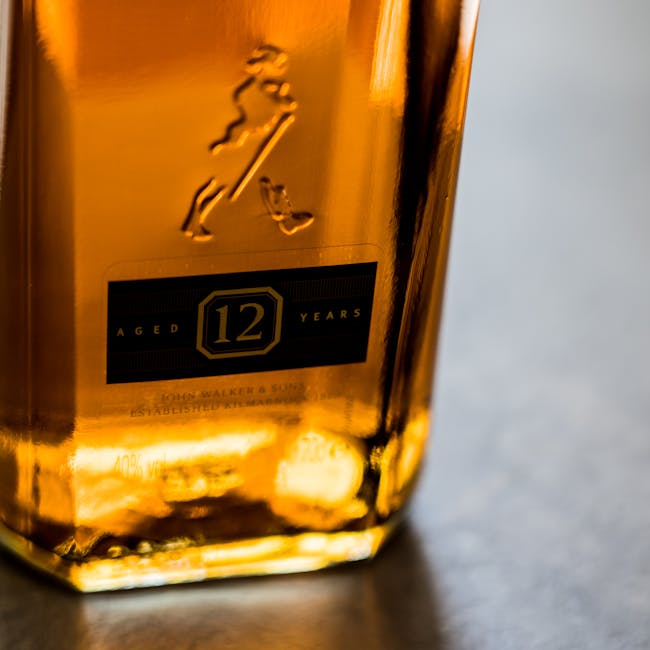 Macro shot of a luxurious 12-year aged whiskey bottle with amber tones.