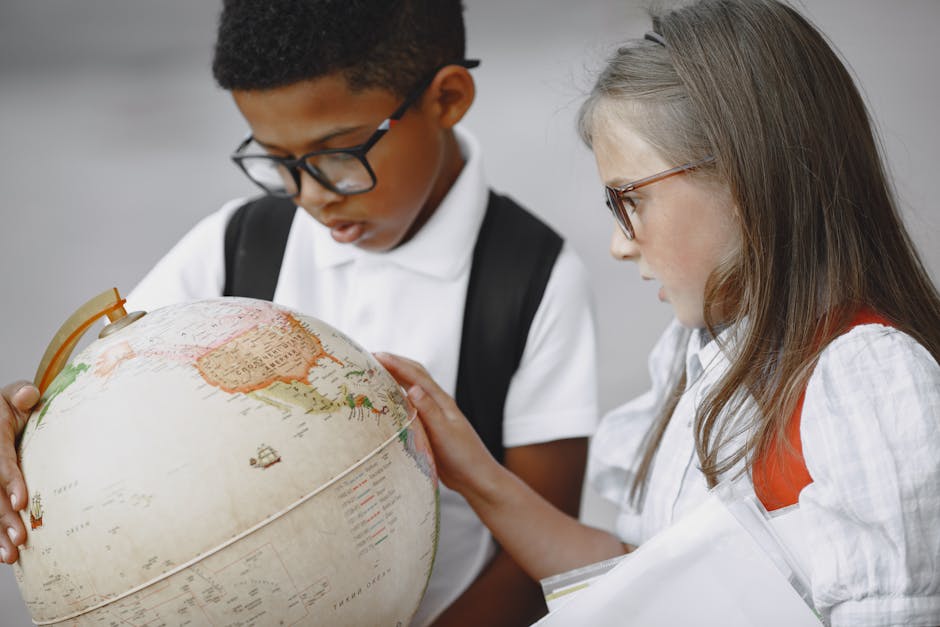 Young students studying geography with a globe, embracing curiosity and global learning in school.
