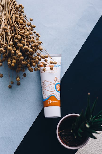 Top view of a baby cosmetic tube with dried herbs, ideal for natural skincare promotions.