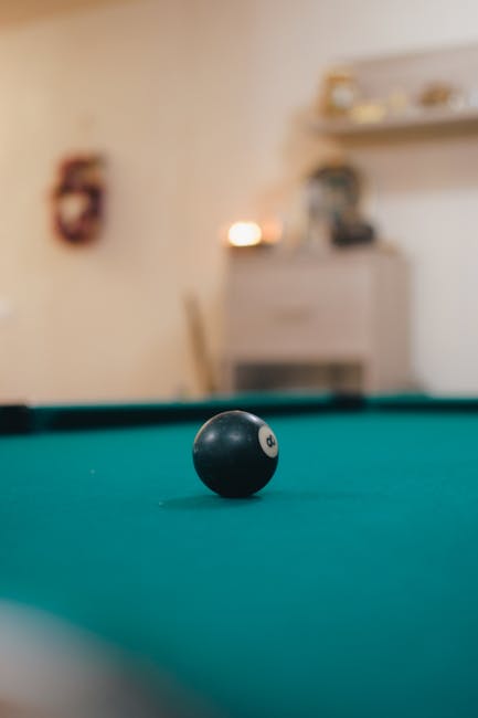 Focused shot of a single 8-ball on a pool table, perfect for sports themes.