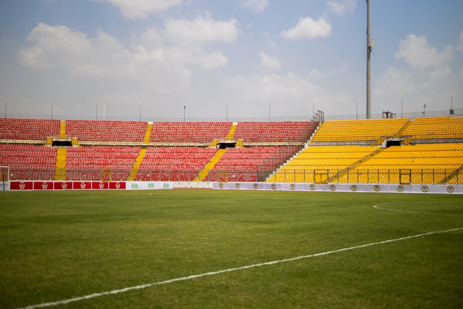 A sunny view of the empty seats and lush grass at Baba Yara Sports Stadium in Kumasi, Ghana.