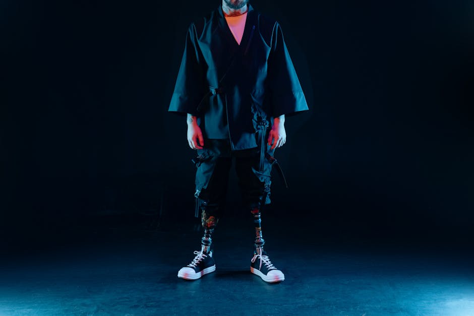 A modern fashion portrait featuring a person with robotic prosthetics and stylish attire.