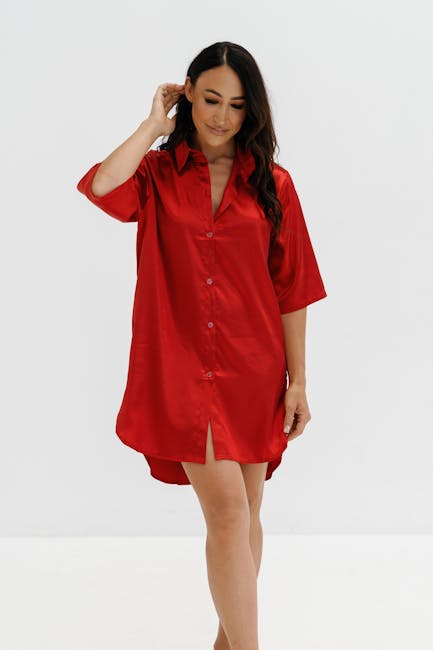 A woman poses in a vibrant red satin dress against a clean white background.